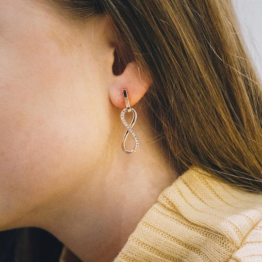 Rose Gold Plated Infinity Drop Earrings Created with Zircondia® Crystals - Philip Jones Jewellery