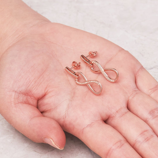 Rose Gold Plated Infinity Drop Earrings Created with Zircondia® Crystals - Philip Jones Jewellery
